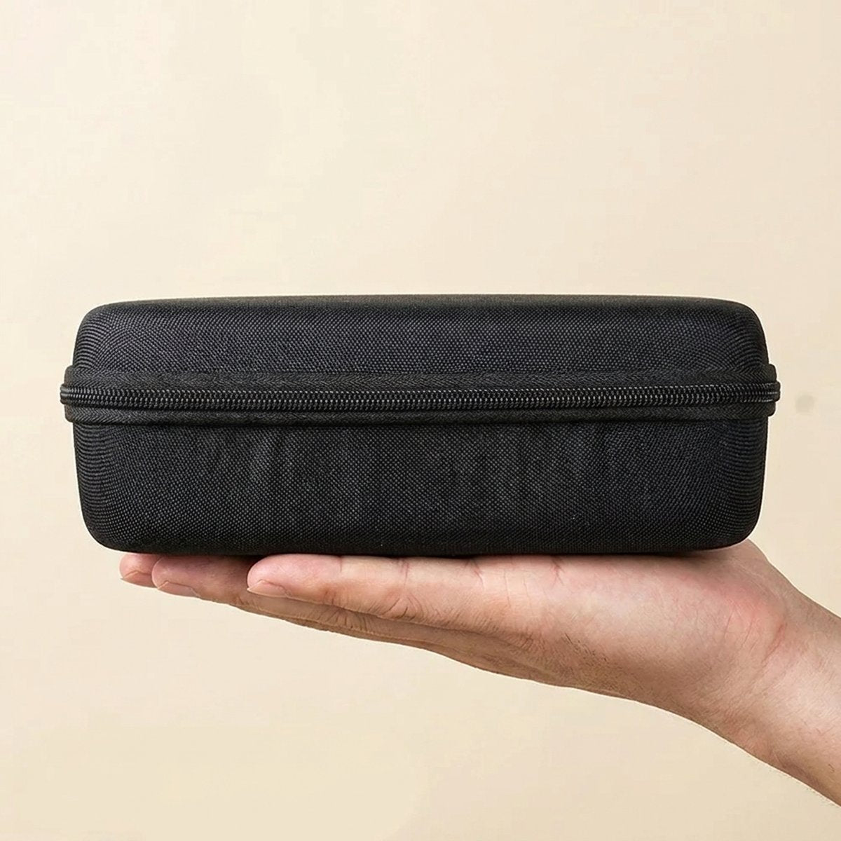 Étui de rangement rigide tenu dans une main pour montrer sa taille
